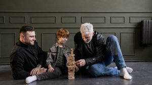 Three generations enjoy a bonding moment playing Jenga indoors.
